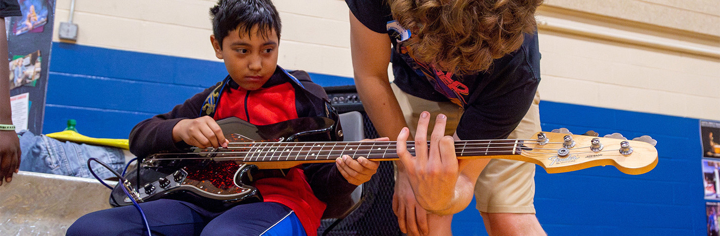 student learning how to play the guitar